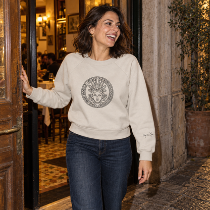 Woman wearing The Pasta Queen Goddess Medallion Sweat in Vintage White, with a black goddess chest design, outside an Italian trattoria.